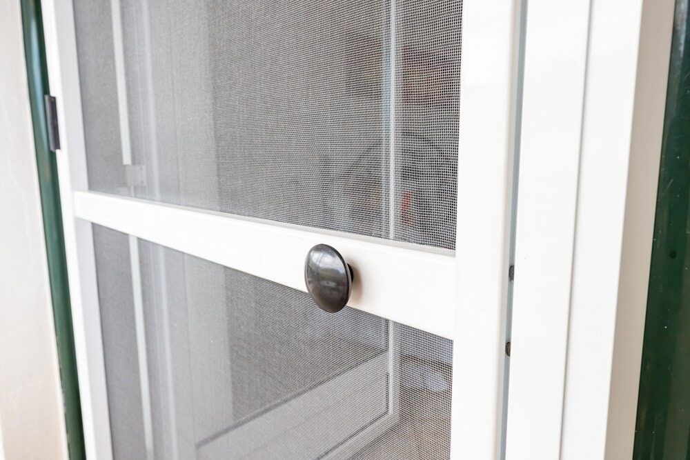 A Close Up Of A White Screen Door With A Black Handle — Summerland Screens & Awnings In Suffolk Park, NSW