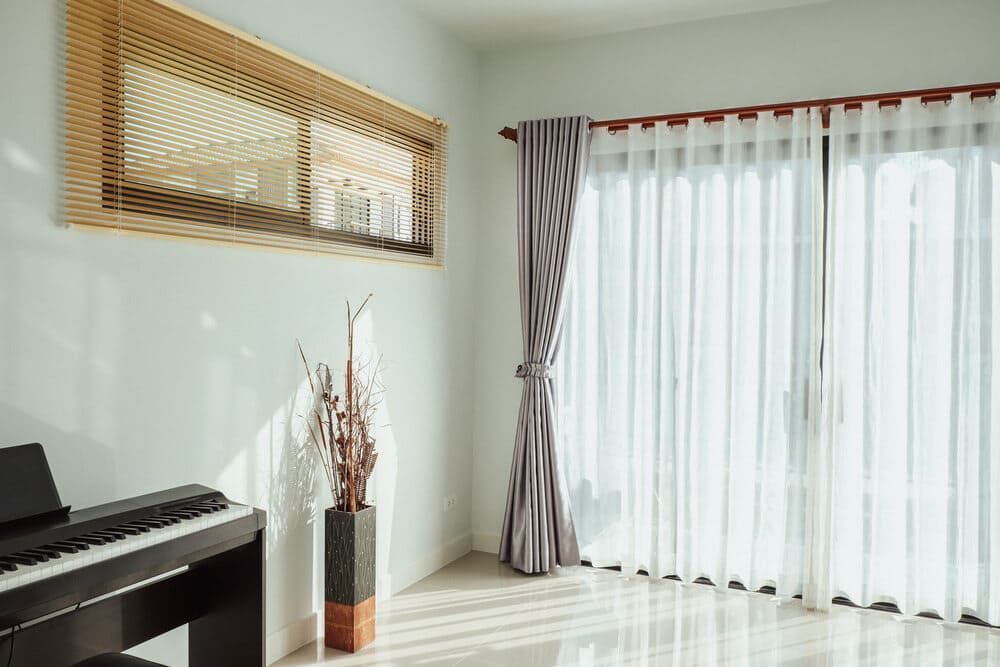 A Living Room With A Piano, Curtains And A Window — Summerland Screens & Awnings In Ballina, NSW