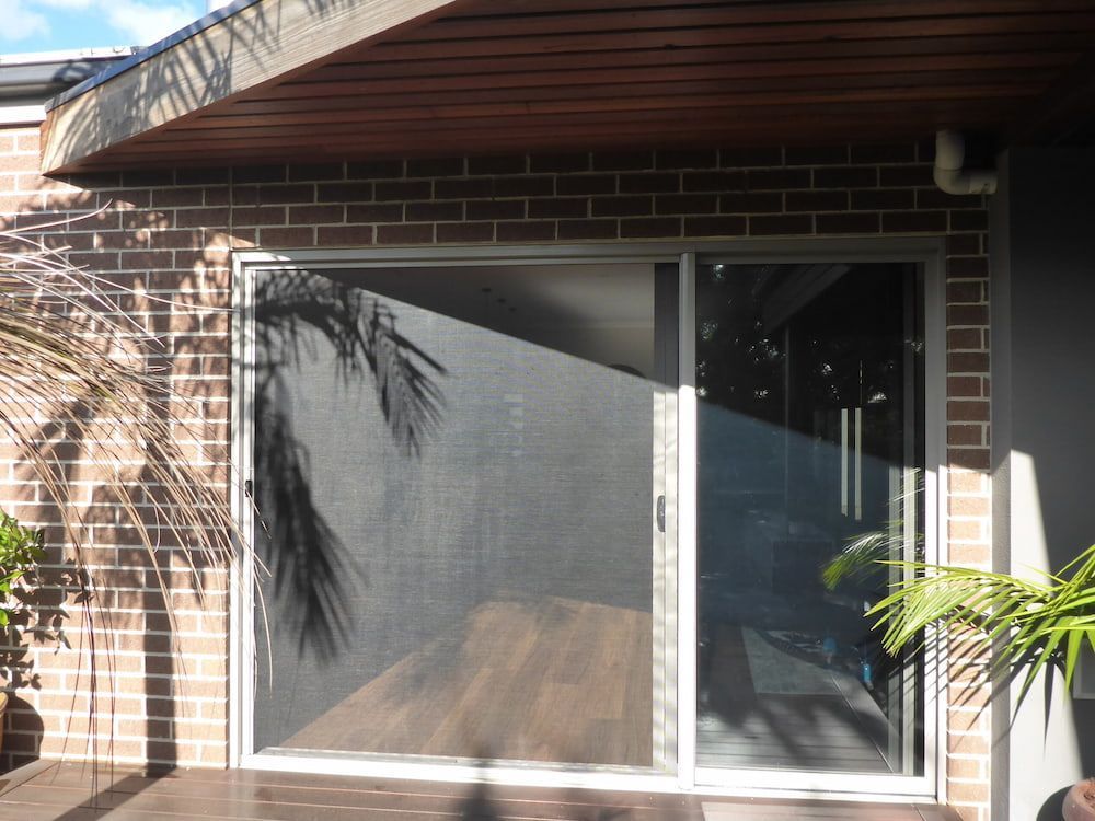 A Brick Building With A Sliding Glass Door — Summerland Screens & Awnings In Ballina, NSW
