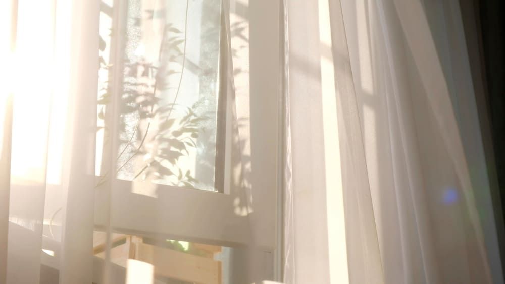 The Sun Is Shining Through The Curtains Of A Window — Summerland Screens & Awnings In Suffolk Park, NSW