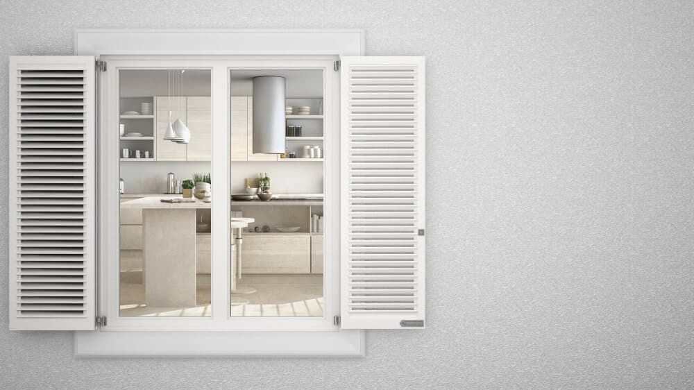 A Kitchen Is Visible Through A Window With White Shutters — Summerland Screens & Awnings In Lennox Head, NSW