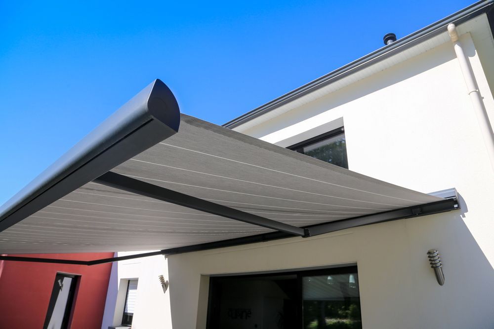 A White House With A Black Awning On The Side Of It — Summerland Screens & Awnings In Ballina, NSW