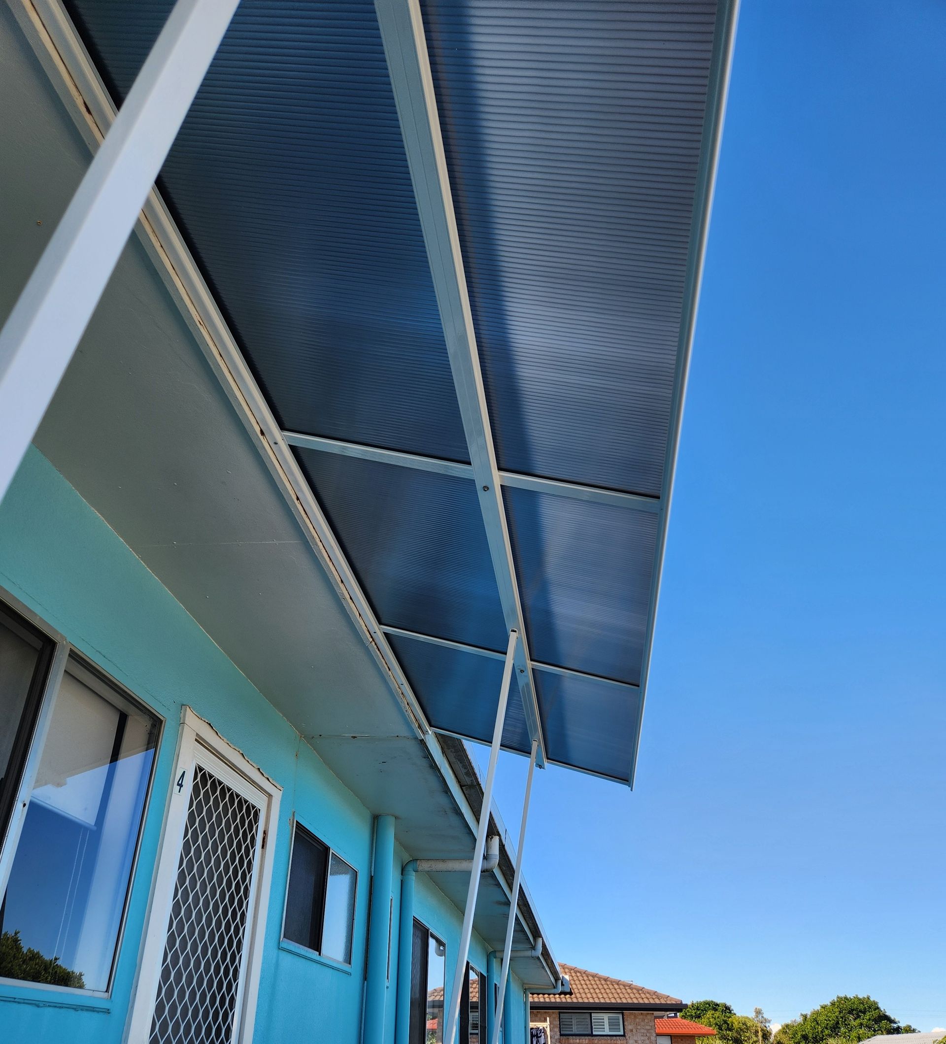 Blue Building With A Corrugated Roof And Blue Sky