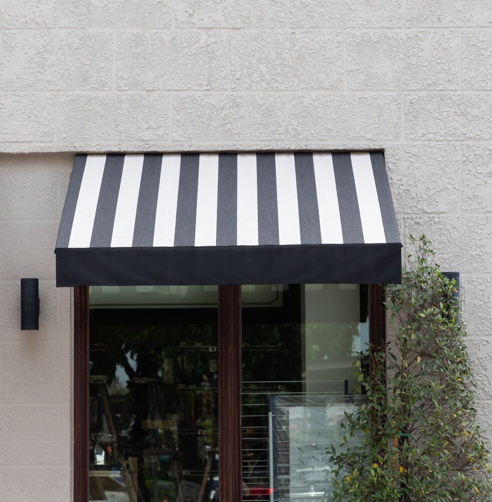 A Black And White Striped Awning Over A Window — Summerland Screens & Awnings In Alstonville, NSW