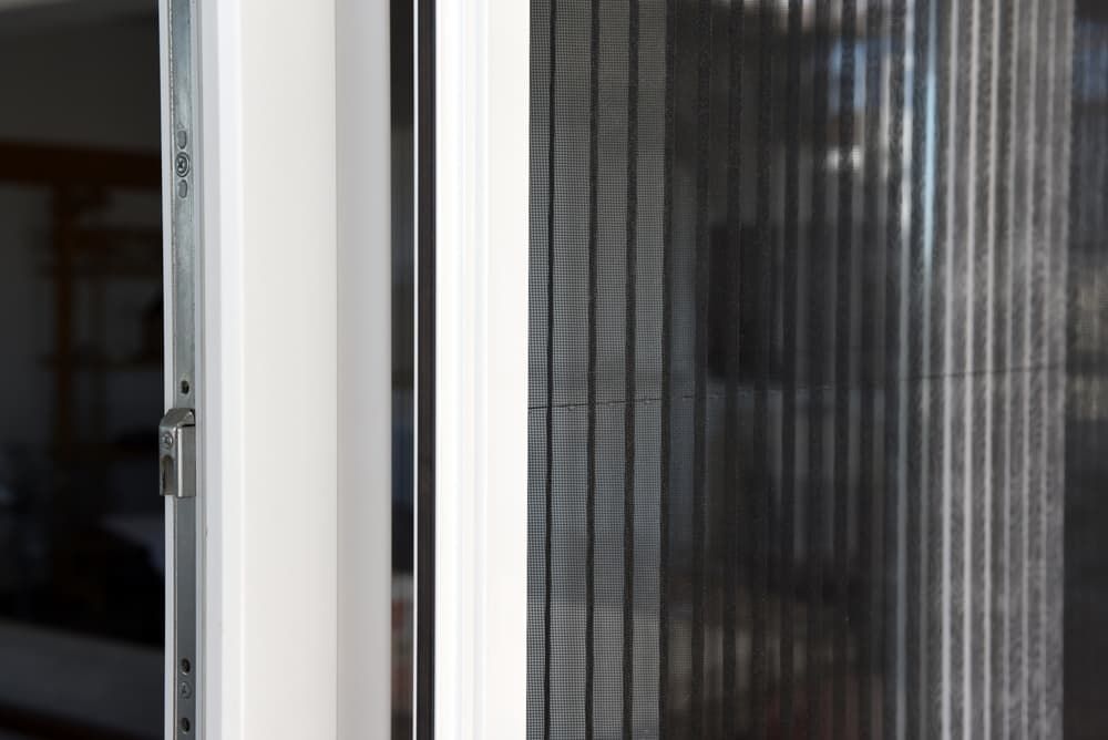 A Close Up Of A Pleated Screen On A Sliding Glass Door — Summerland Screens & Awnings In Lismore, NSW