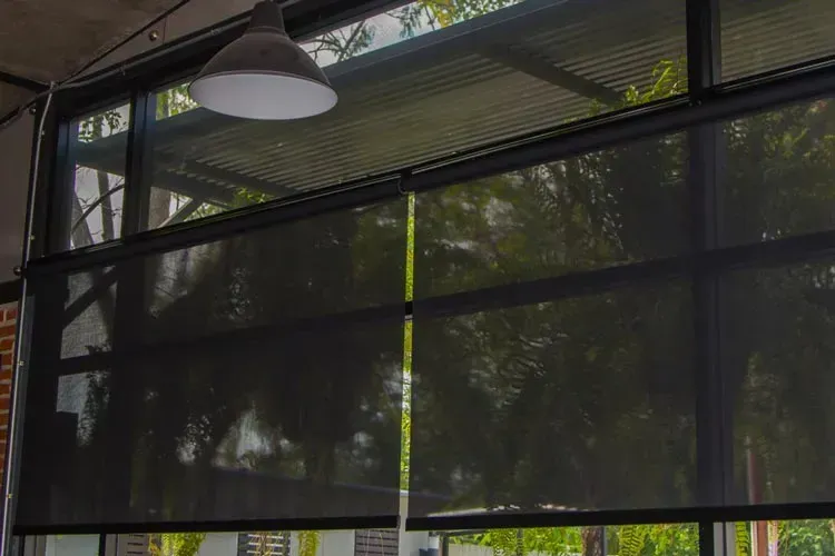 A Close Up Of A Window With Black Blinds On It — Summerland Screens & Awnings In Ballina, NSW