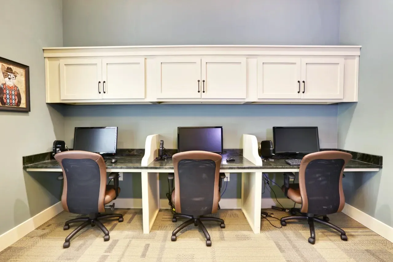 Three desks with computers and chairs in a resident computer lab.