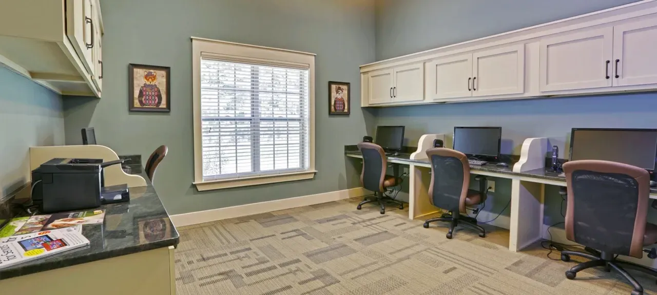 Community computer lab with row of desks, monitors, and office chairs.