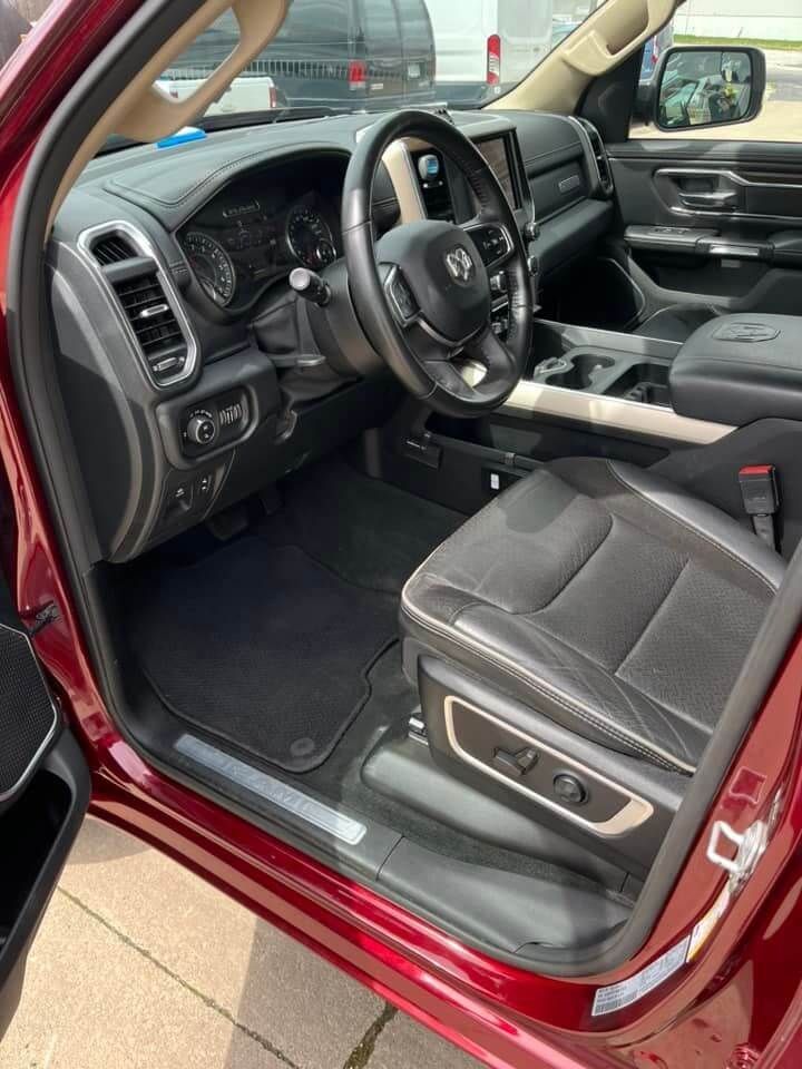 Interior of a maroon truck showing the driver's seat, dashboard, steering wheel, and black upholstery.