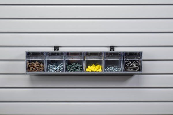 A shelf filled with nuts and bolts on a wall.