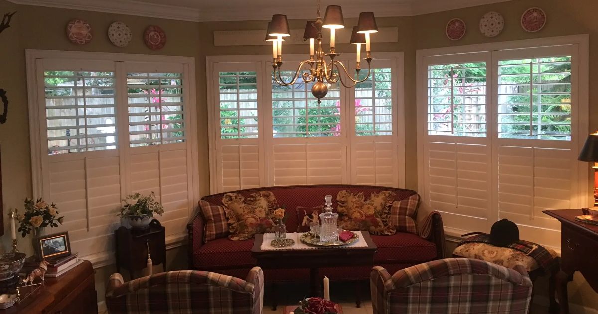 A living room with a couch , chairs , and a chandelier.