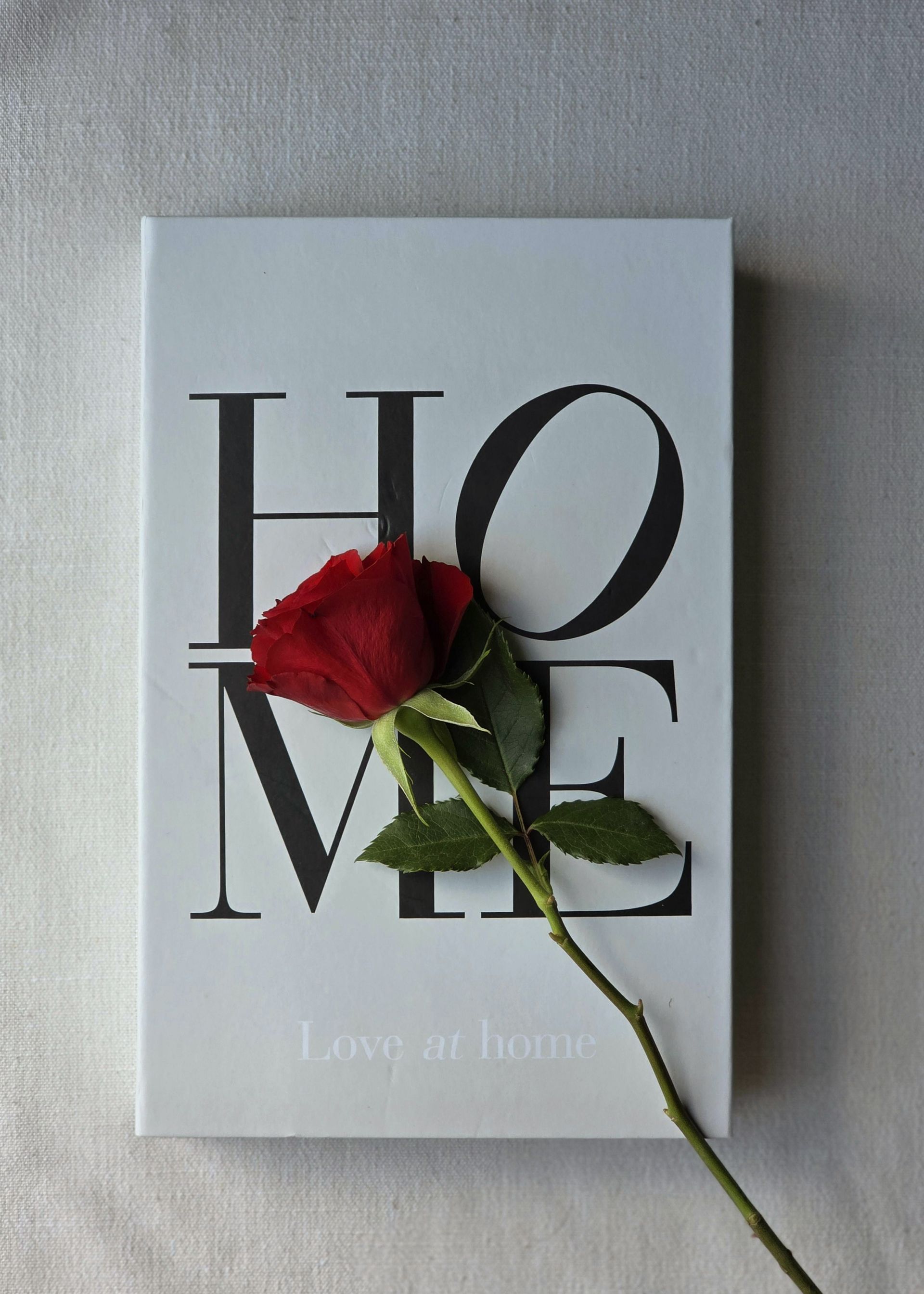 White kitchen cabinets with black stove and stainless steel sink.