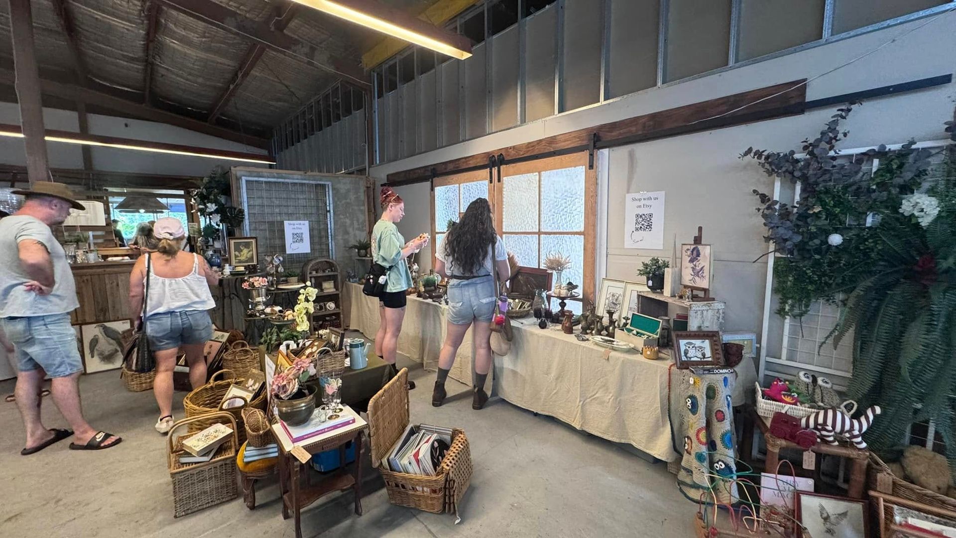 People browsing goods at an indoor market. Various items displayed on tables, walls, and shelves  — Rustique on the Coast In Ourimbah, NSW