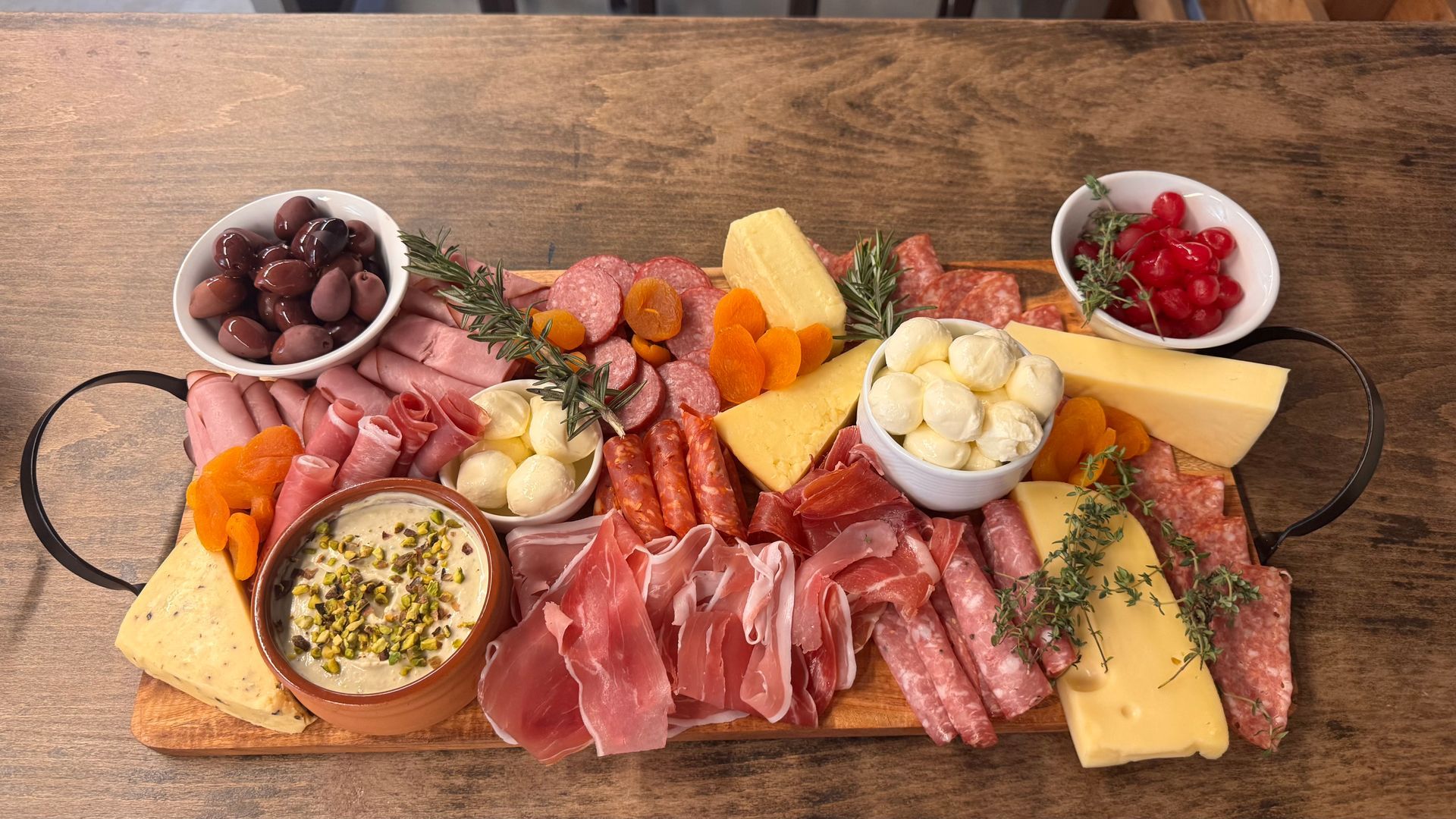 Charcuterie board: meats, cheeses, olives, apricots, and nuts arranged on a wooden platter  — Rustique on the Coast In Ourimbah, NSW