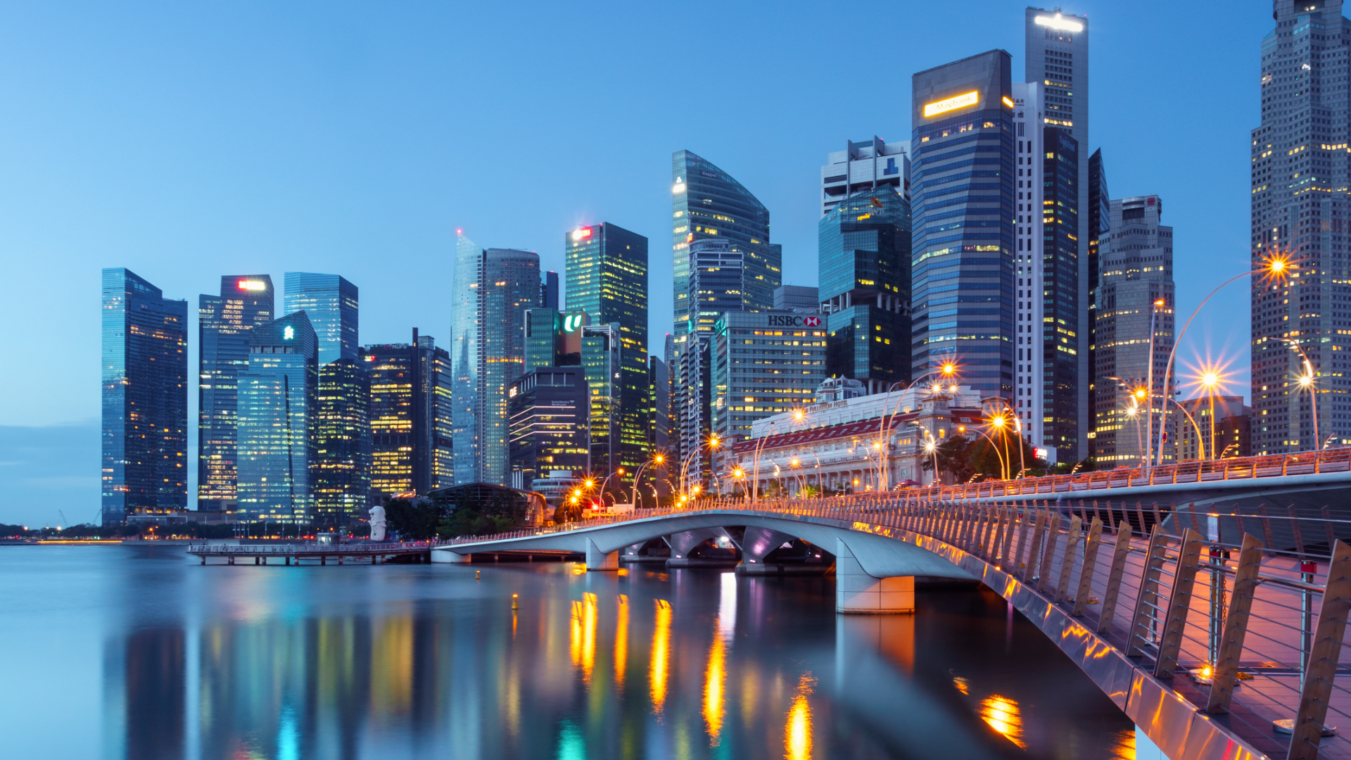 Skyscrapers with glass facades against a bright sun in a blue sky.