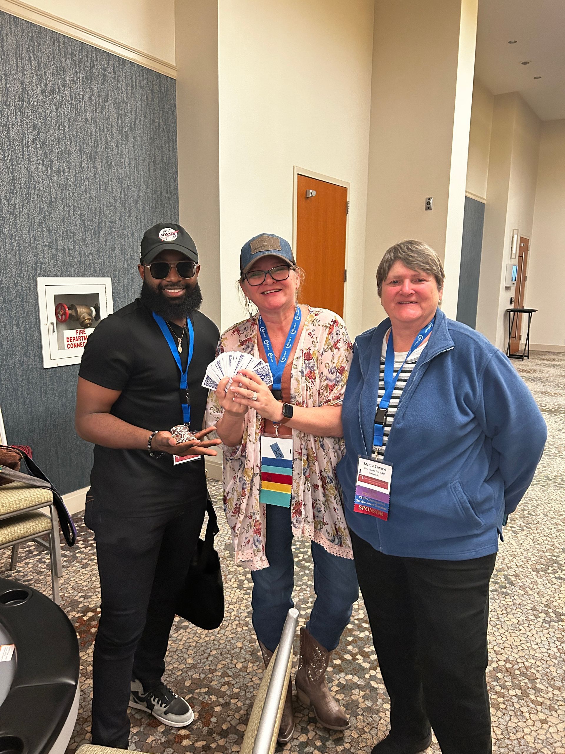 A man and two women are posing for a picture in a hallway.