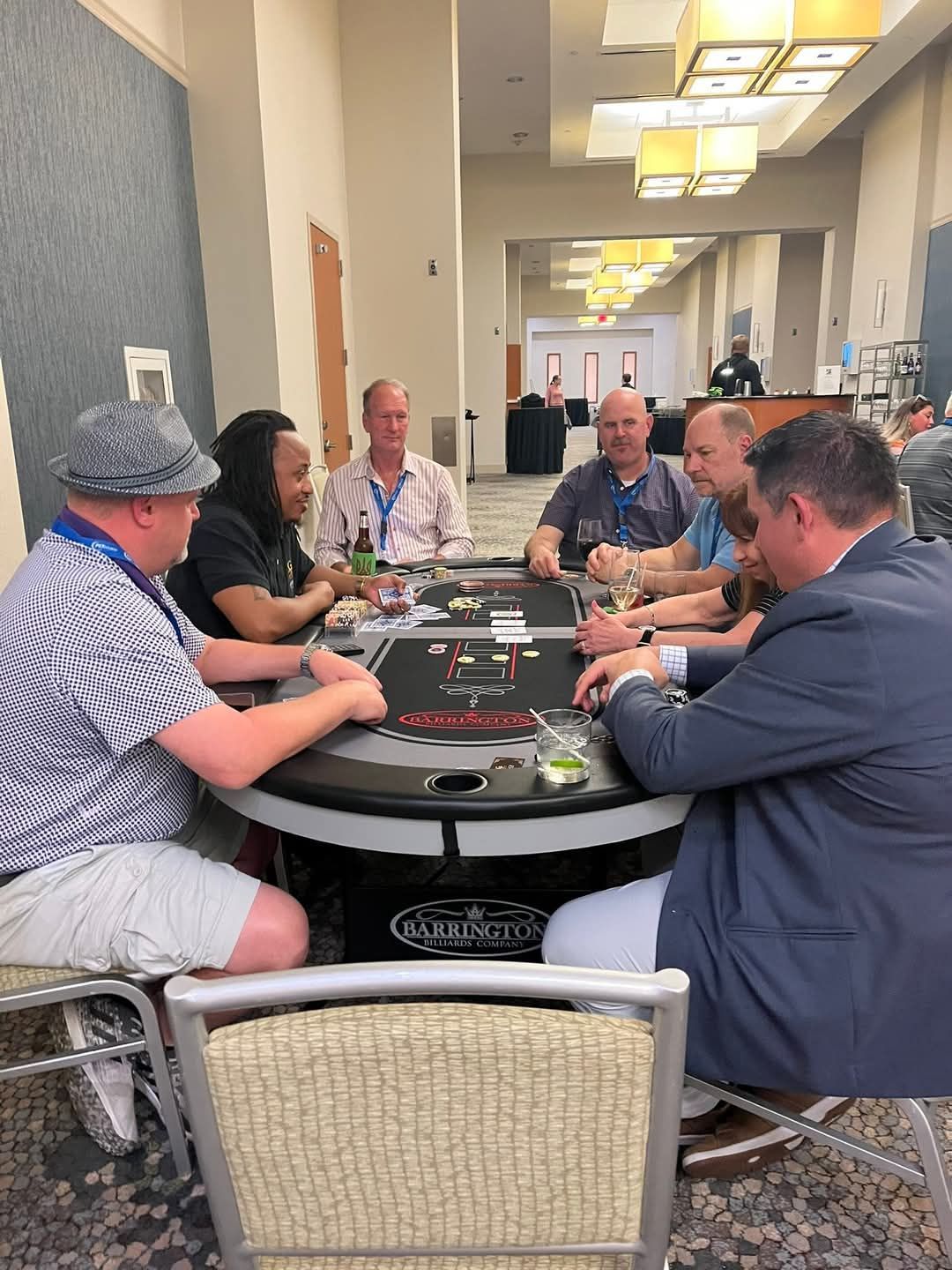 A group of men are sitting around a table playing poker
