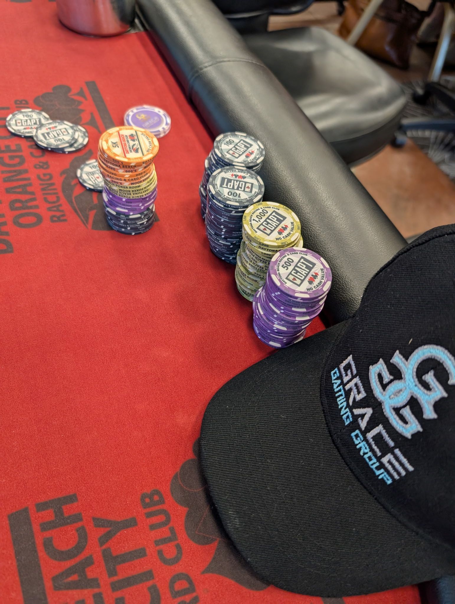 Stacks of poker chips on a table with a hat that says grace