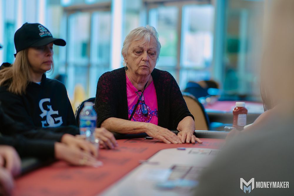 A group of people are sitting at a table playing poker.