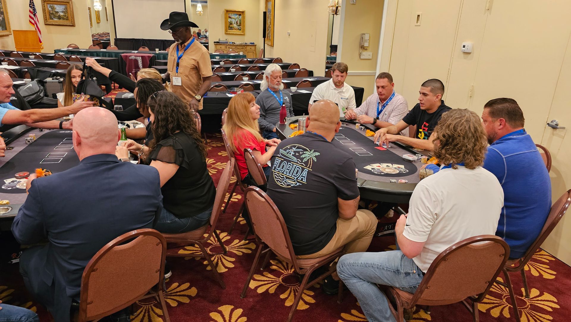 A group of people are sitting at tables in a room playing poker.