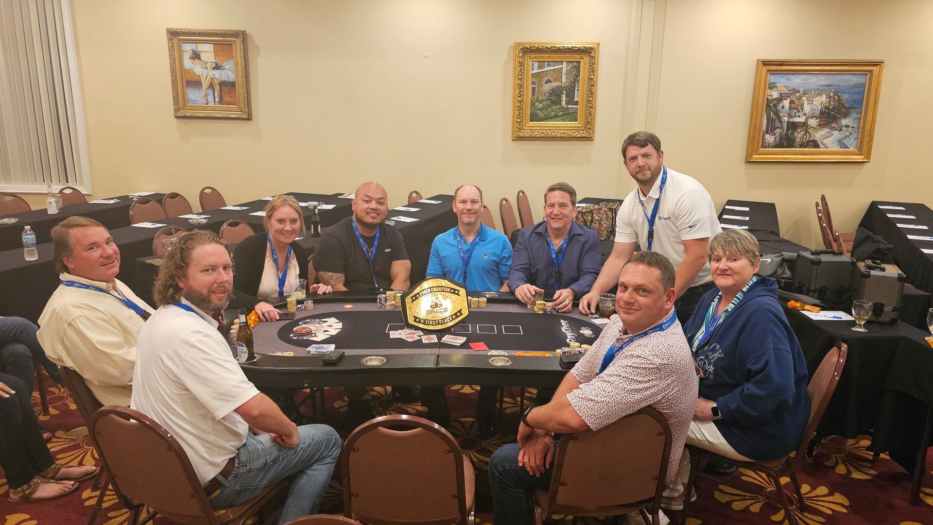 A group of people are sitting around a poker table.