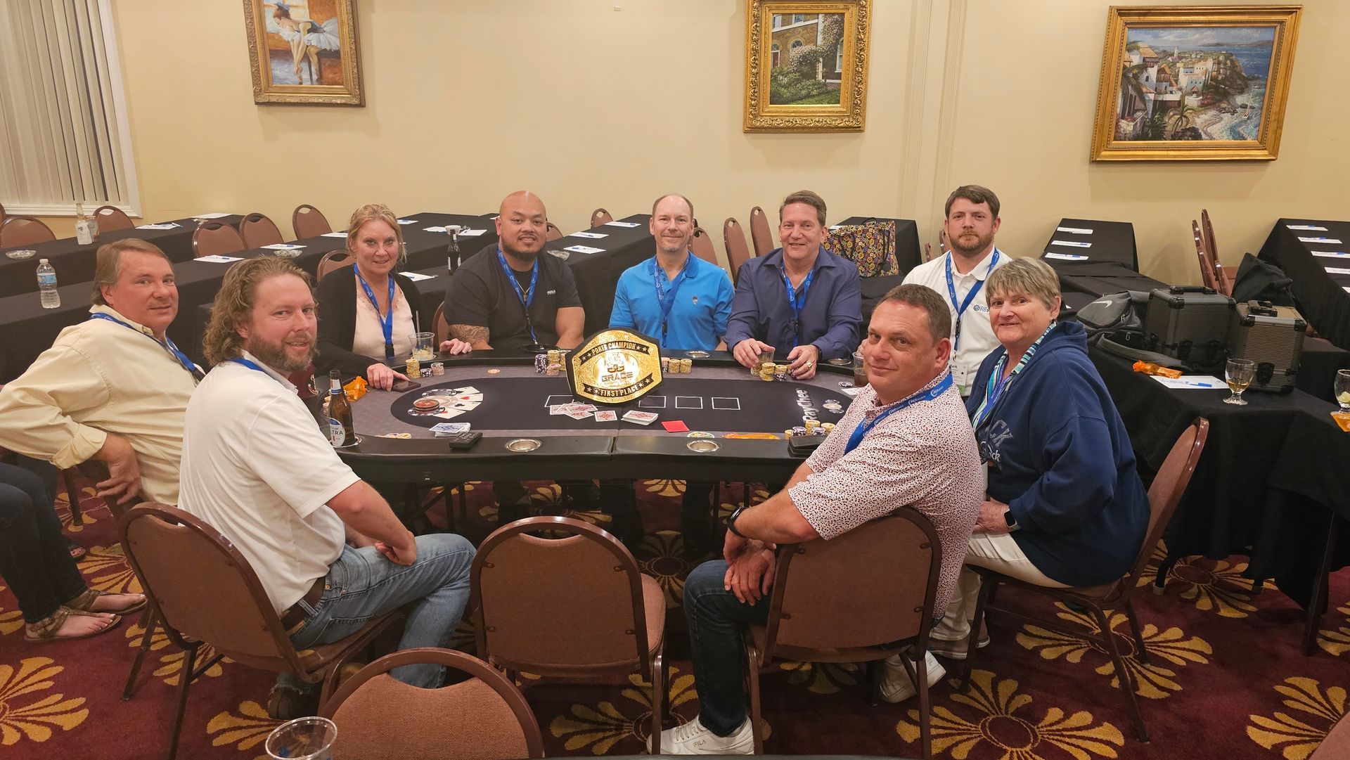 A group of people are sitting around a poker table.