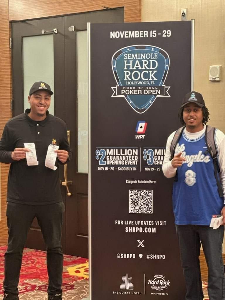 Two men are standing in front of a sign that says female hard rock