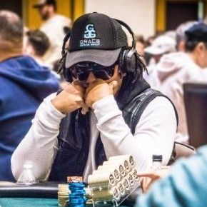 A man wearing headphones and sunglasses is sitting at a poker table.