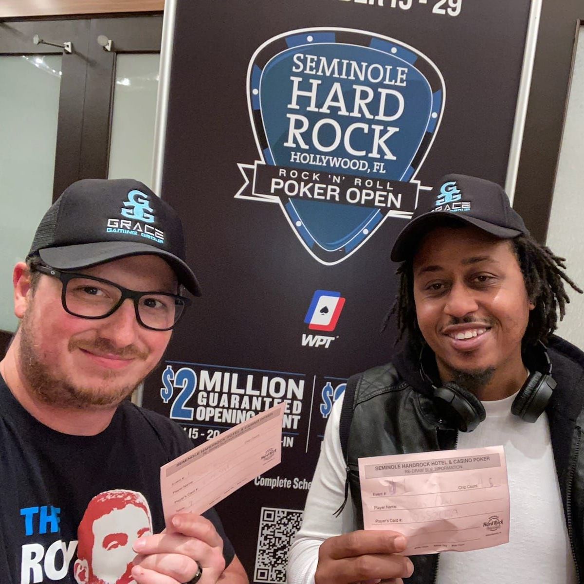 Two men standing in front of a sign that says seminole hard rock
