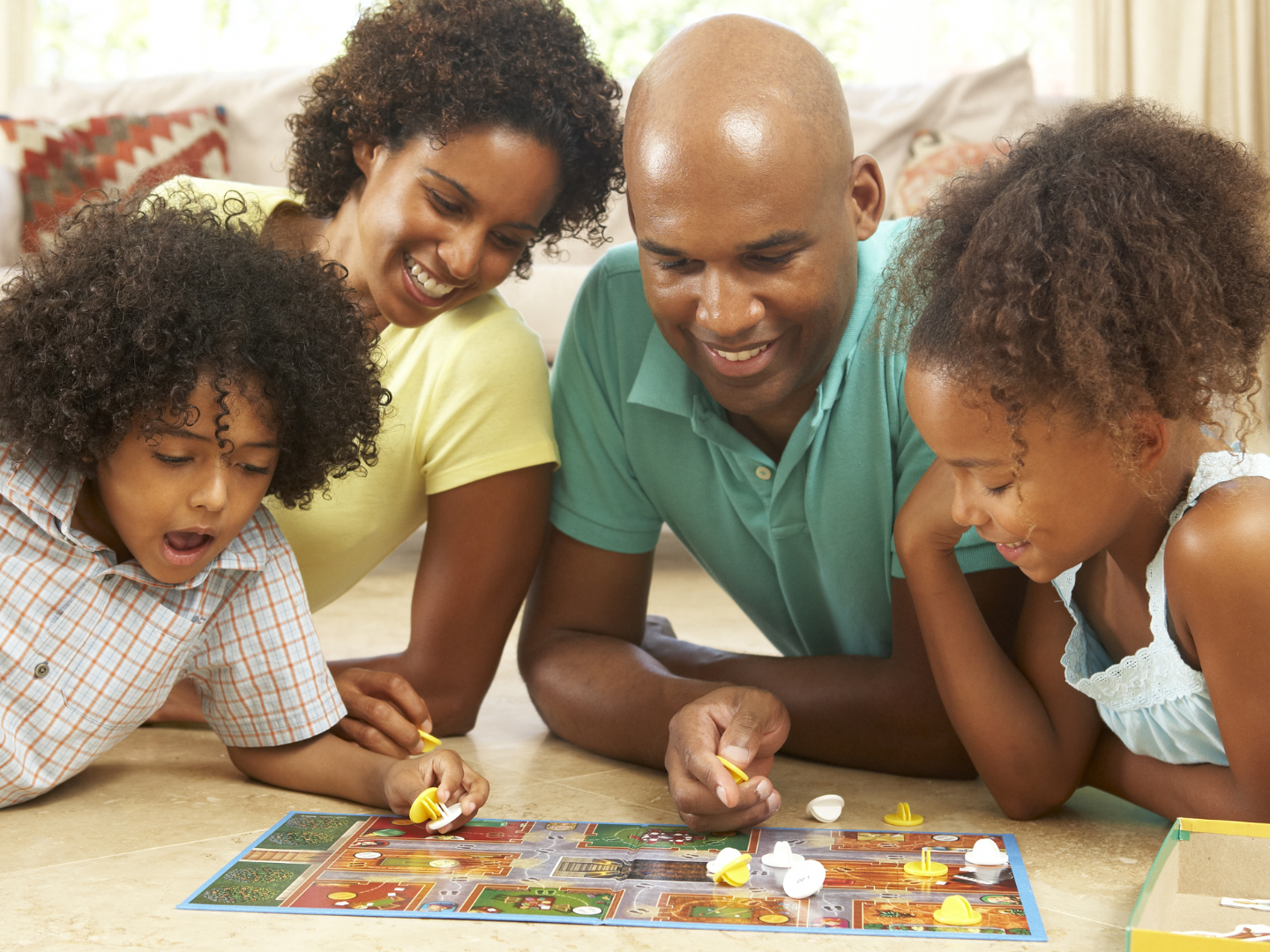 A family is laying on the floor playing a board game