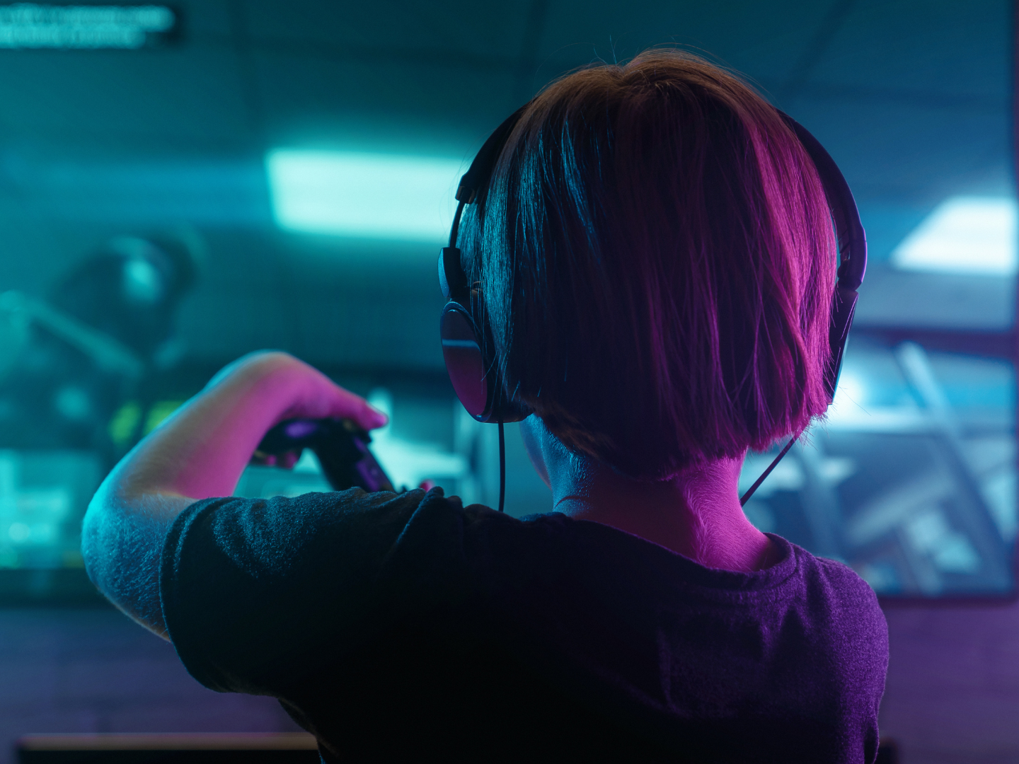 A young boy wearing headphones is playing a video game.