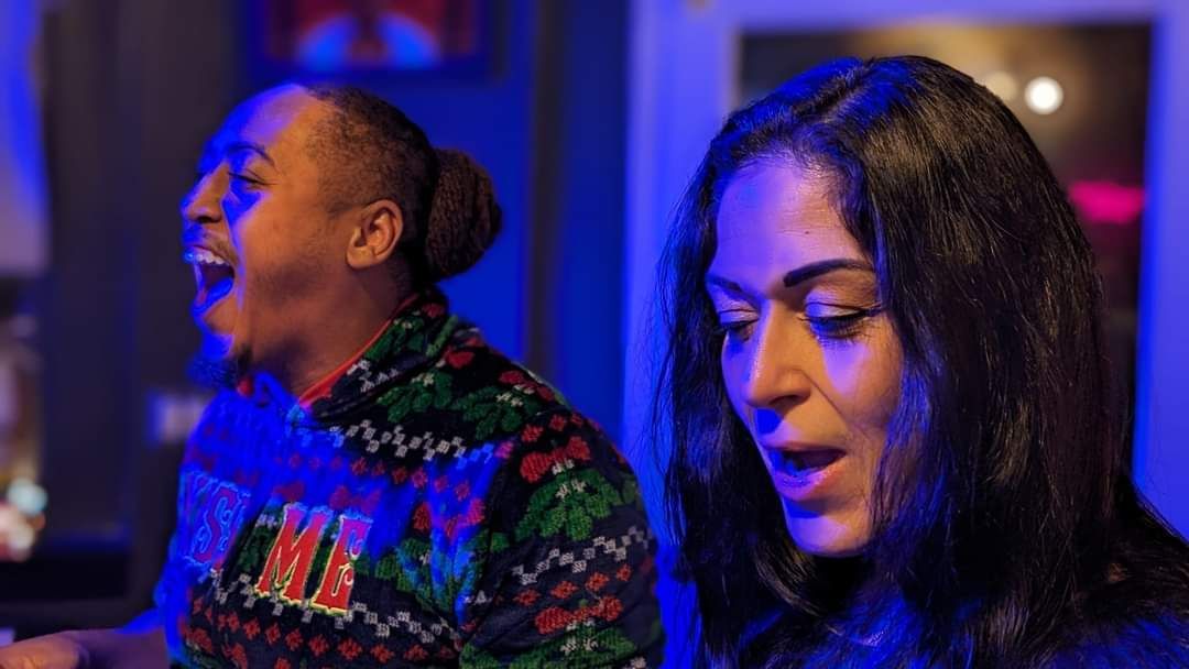 Two women are sitting next to each other in a room with blue lights.