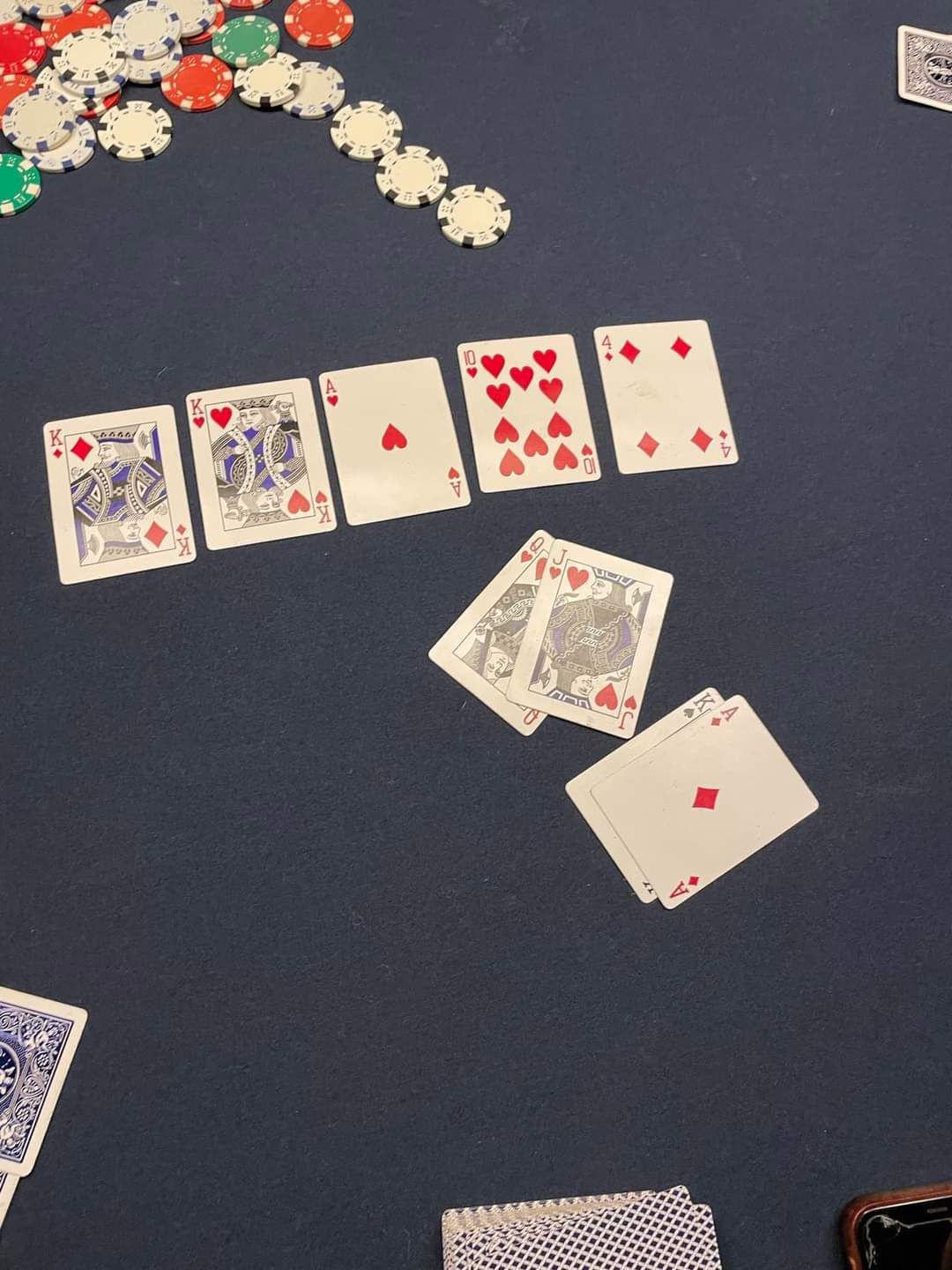 A row of playing cards on a table with chips in the background