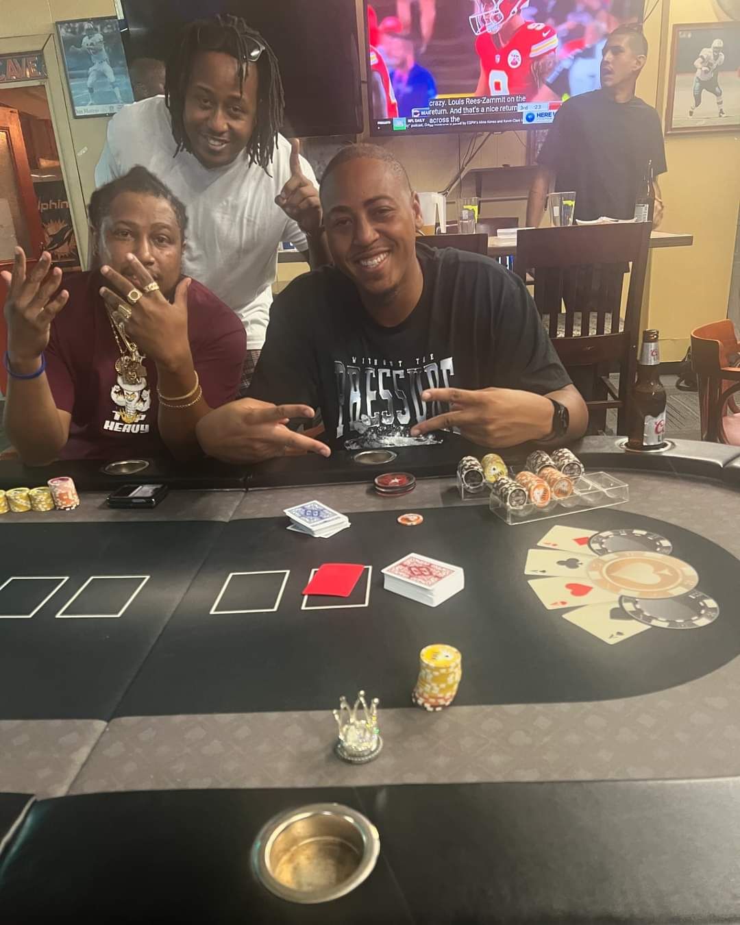 A group of people are posing for a picture at a poker table