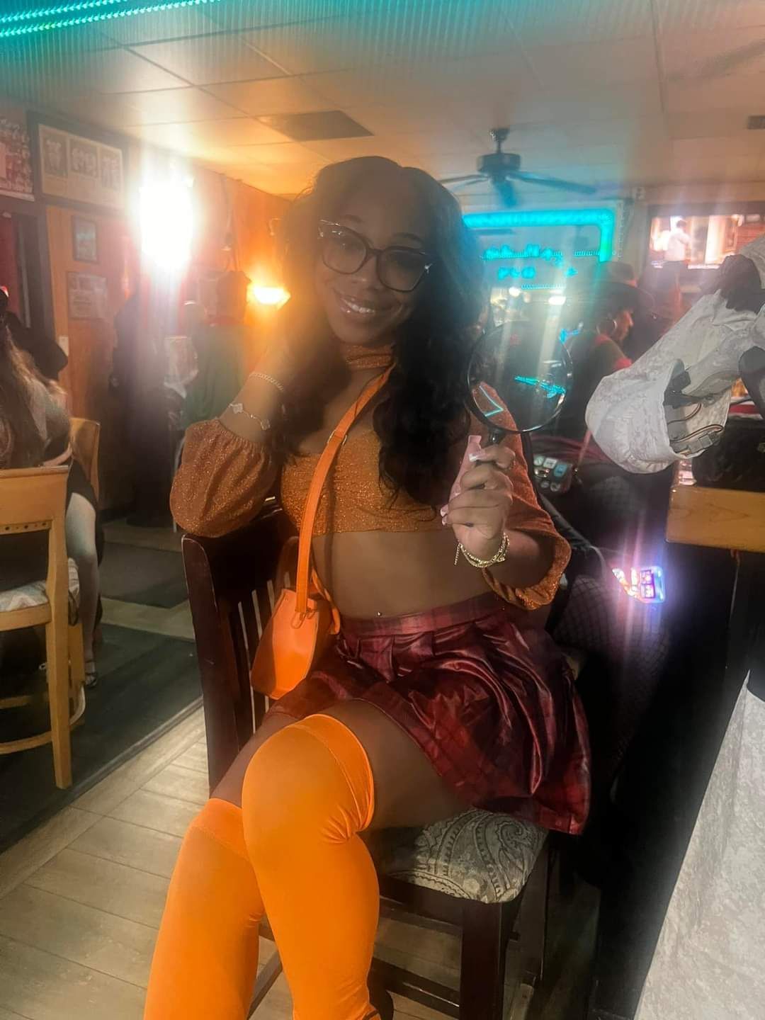 A woman in a scooby doo costume is sitting in a chair in a restaurant.