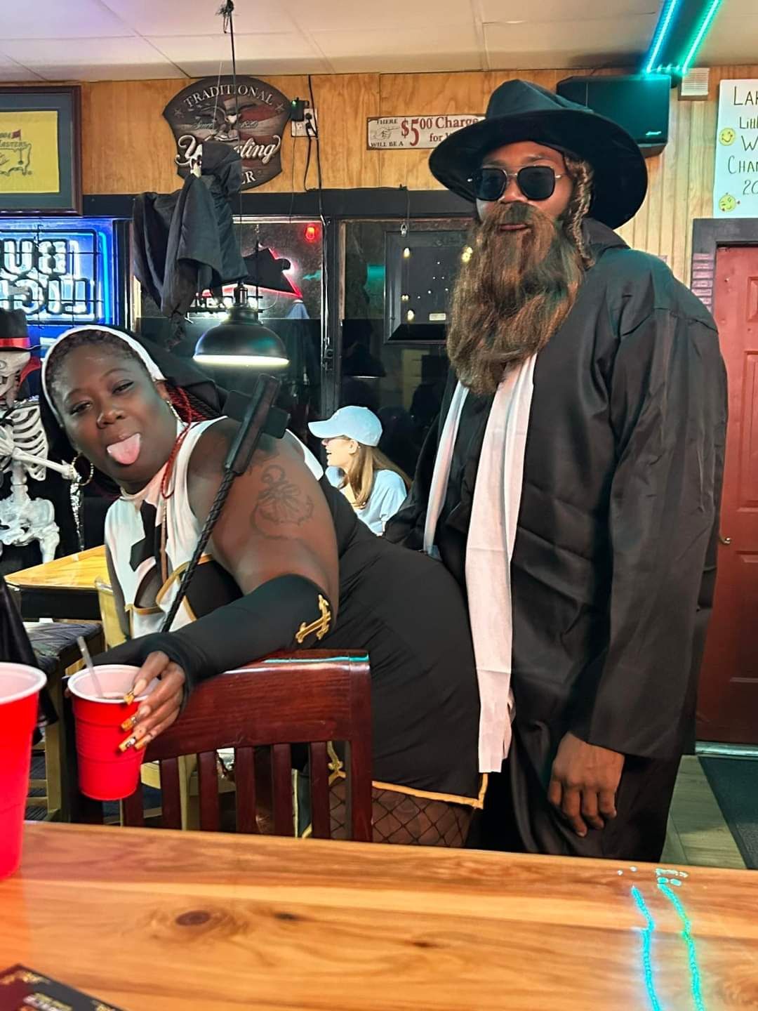 A man with a beard is standing next to a woman in a witch costume