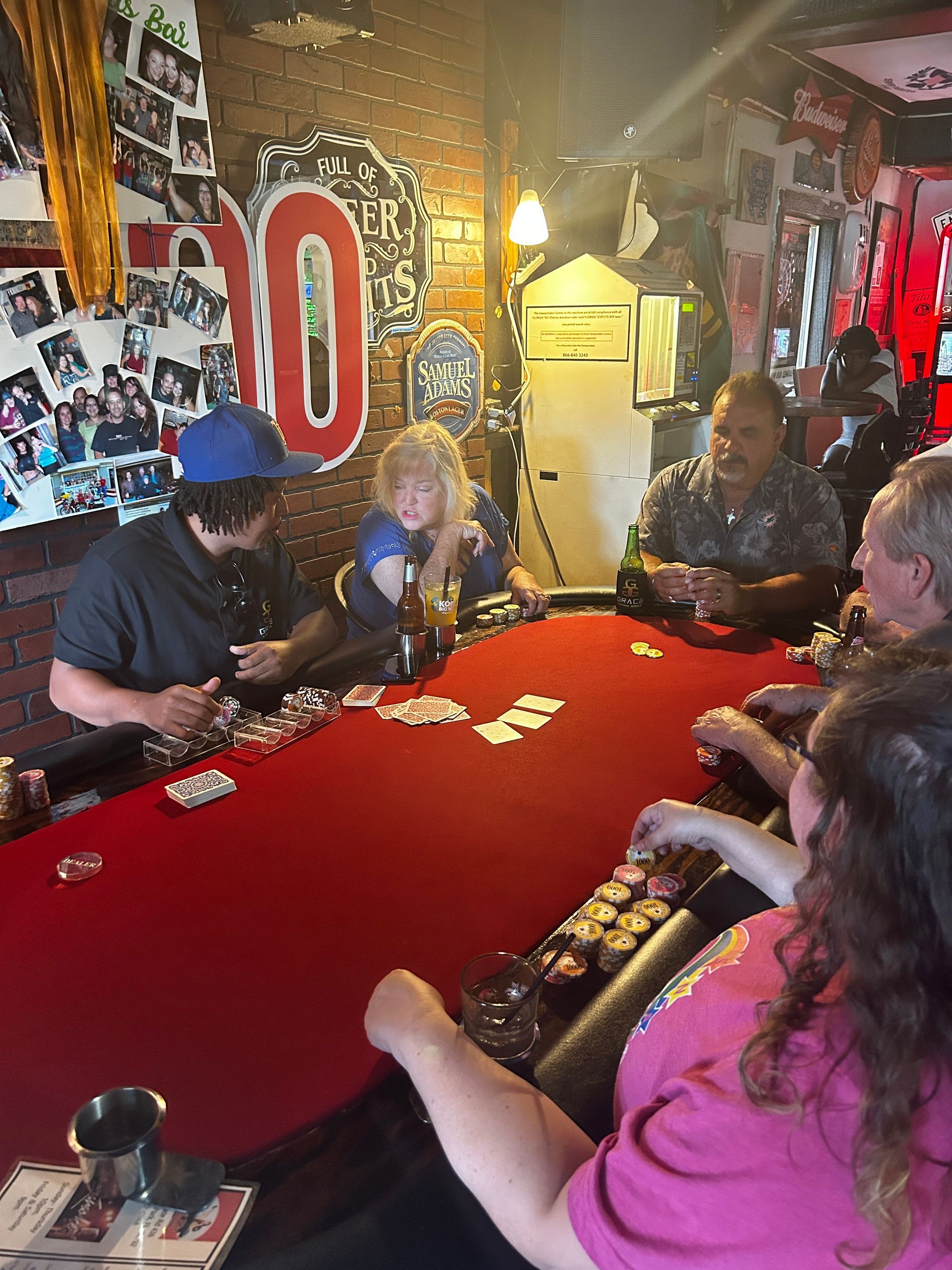 A group of people are sitting around a table playing cards.