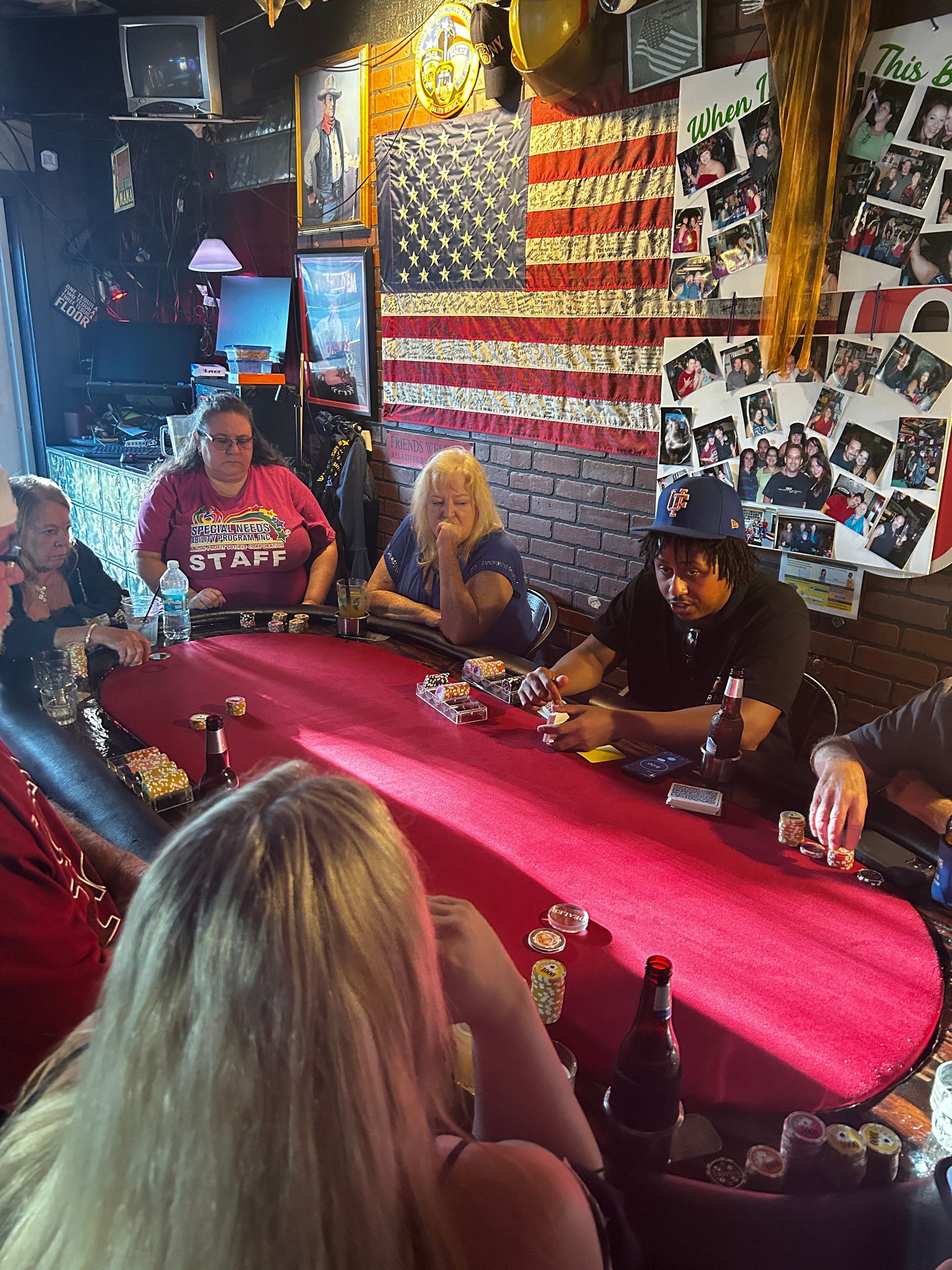 A group of people are sitting around a table in a bar.