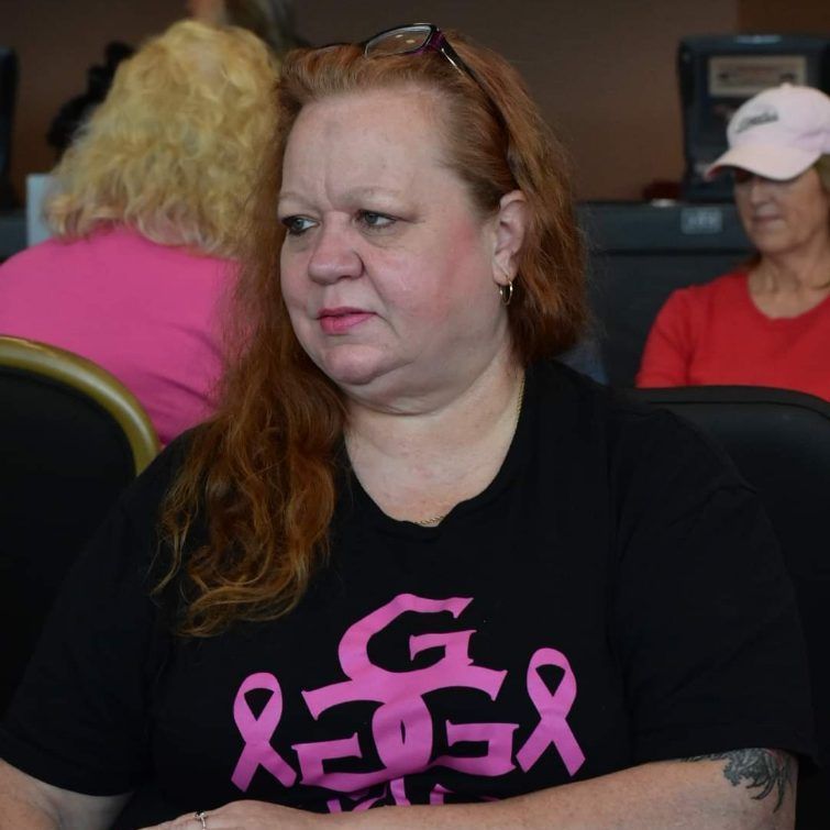 A woman wearing a black shirt with pink ribbons on it