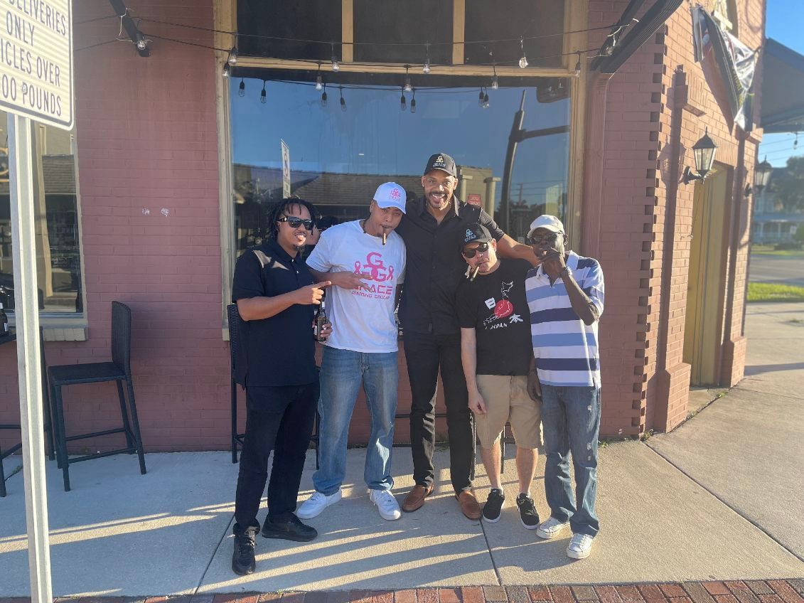 A group of men are posing for a picture in front of a building.