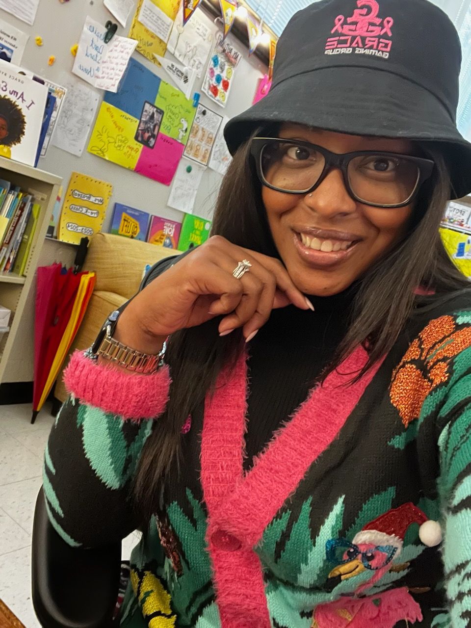 A woman wearing a hat and glasses is smiling