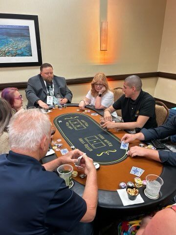 A group of people are sitting around a table playing poker.
