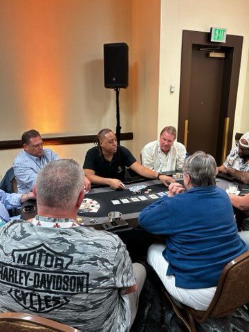 A group of people are sitting around a table playing poker.