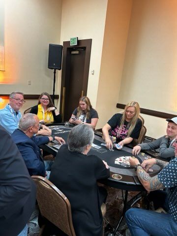 A group of people are sitting around a table playing poker.