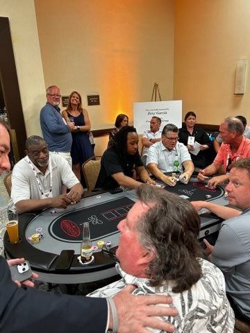 A group of people are sitting around a table playing poker.
