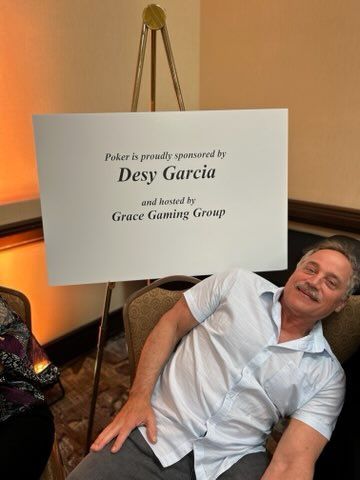 A man is sleeping under a sign that says desy garcia
