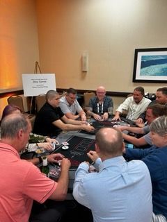 A group of people are sitting around a table playing poker.
