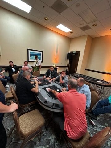 A group of people are sitting around a table playing poker.