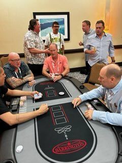 A group of men are sitting around a poker table.