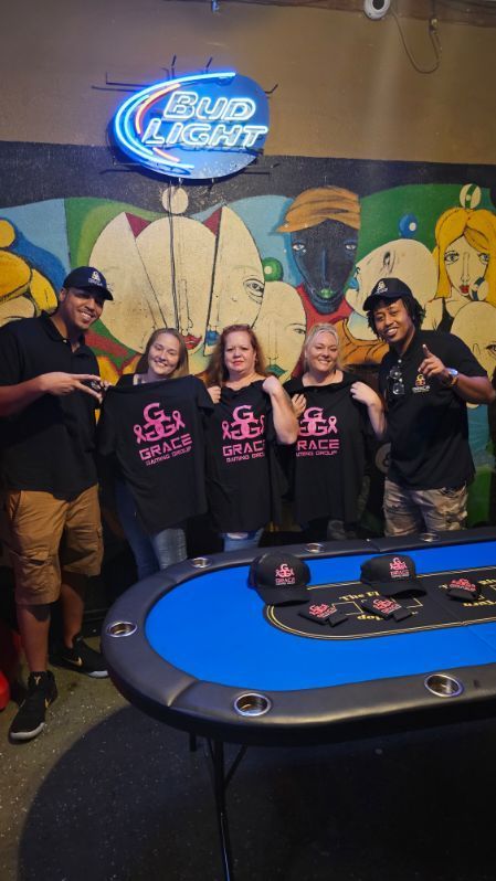 A group of people are posing for a picture in front of a bud light sign.